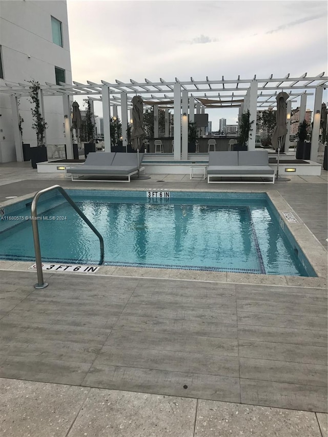 view of swimming pool featuring a pergola and a patio