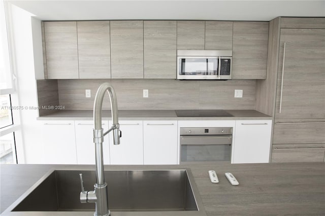 kitchen with tasteful backsplash, appliances with stainless steel finishes, and sink