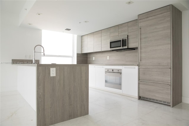 kitchen with appliances with stainless steel finishes and backsplash