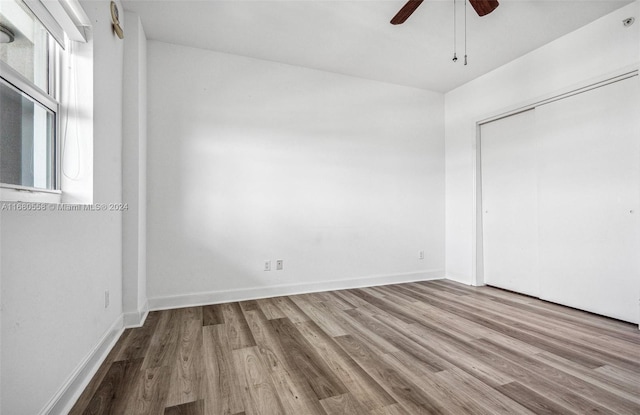 unfurnished bedroom with light hardwood / wood-style flooring, a closet, and ceiling fan