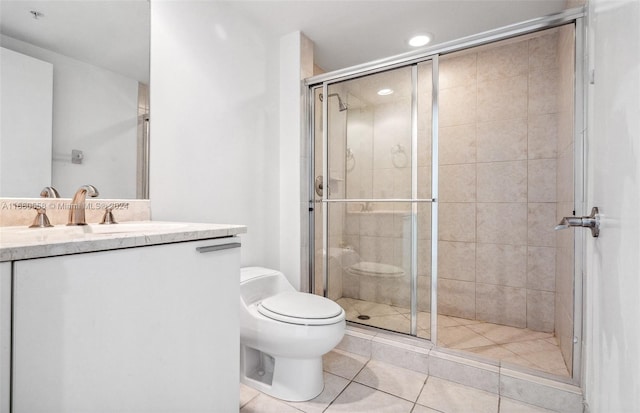 bathroom with vanity, tile patterned flooring, toilet, and an enclosed shower