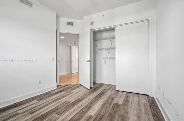 unfurnished bedroom featuring a closet and hardwood / wood-style floors