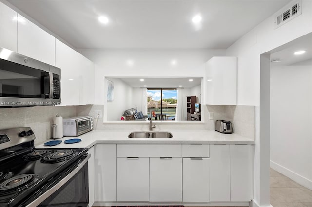 kitchen with backsplash, stainless steel appliances, sink, and white cabinets