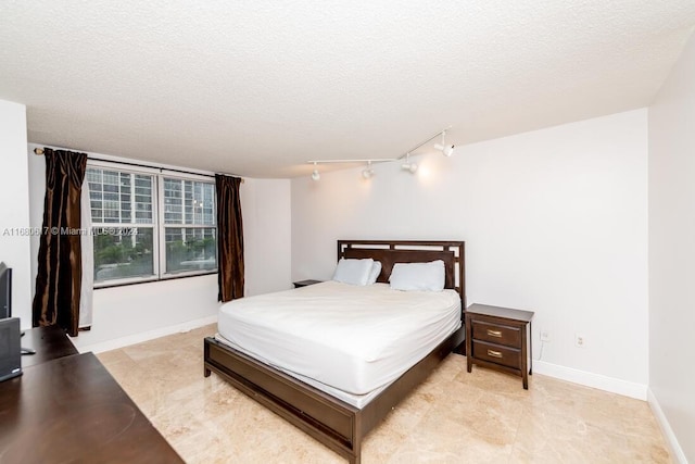 bedroom featuring a textured ceiling and rail lighting