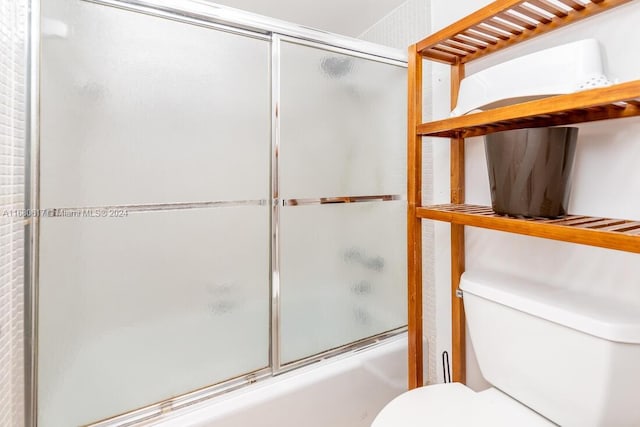 bathroom featuring toilet and enclosed tub / shower combo