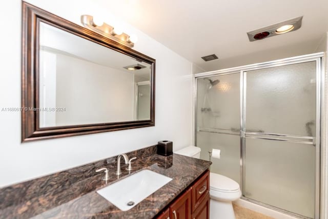 bathroom with vanity, tile patterned flooring, toilet, and walk in shower