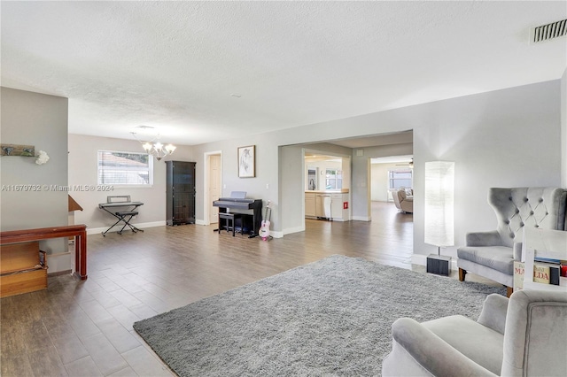 living room featuring dark hardwood / wood-style floors, a chandelier, and a textured ceiling