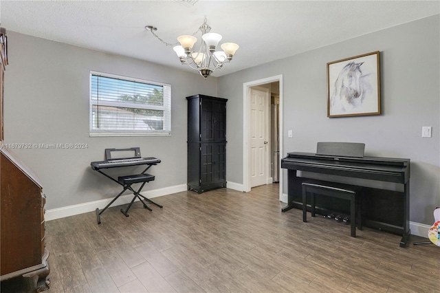 misc room with wood-type flooring and an inviting chandelier