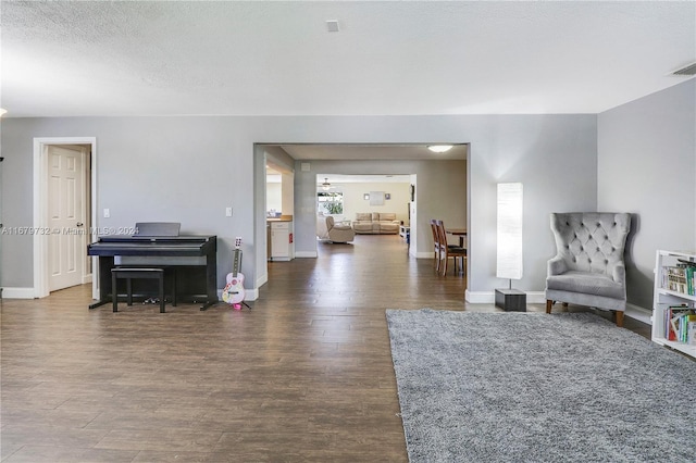 living area featuring a textured ceiling and dark hardwood / wood-style flooring