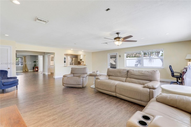 living room featuring light hardwood / wood-style flooring and ceiling fan