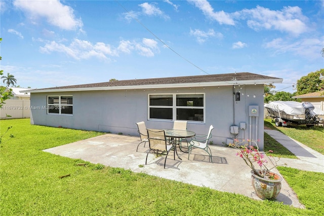 rear view of house featuring a patio area and a lawn