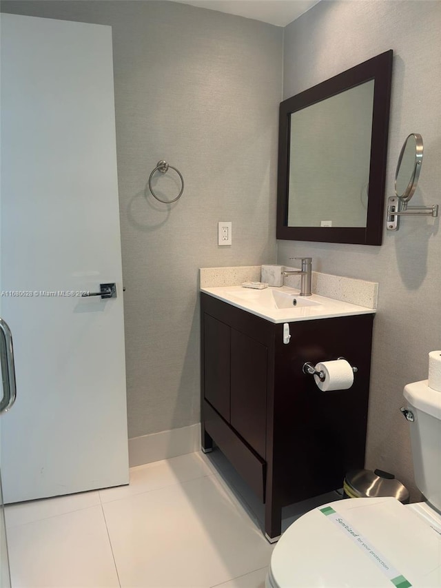 bathroom with vanity, toilet, and tile patterned flooring