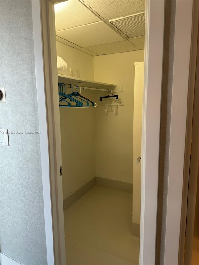 spacious closet featuring a paneled ceiling and tile patterned floors