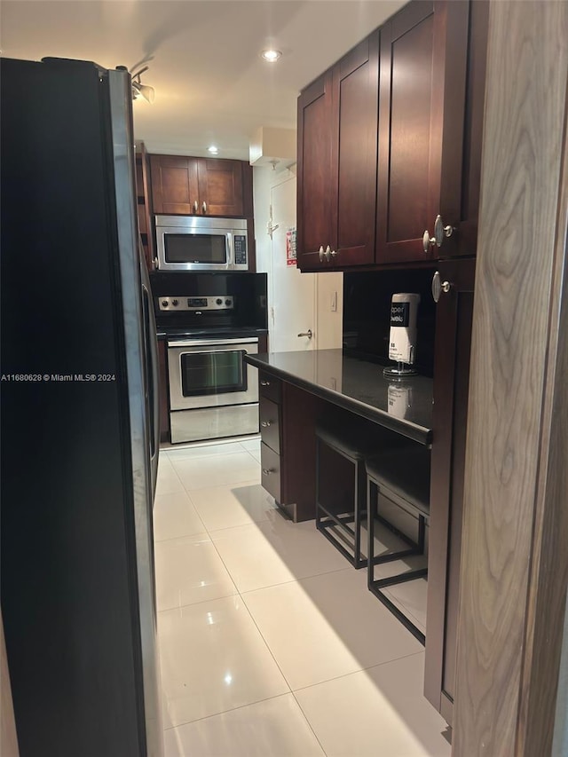 kitchen featuring light tile patterned flooring and stainless steel appliances