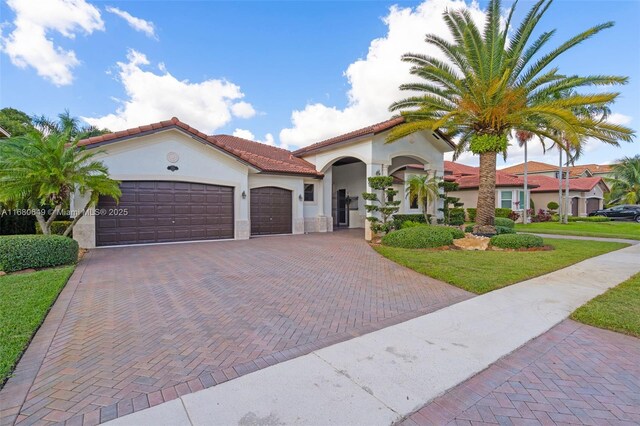 2294 SW 195th Ave, Miramar, FL 33029 - mediterranean / spanish home featuring stucco siding, decorative driveway, an attached garage, a tile roof, and a front lawn