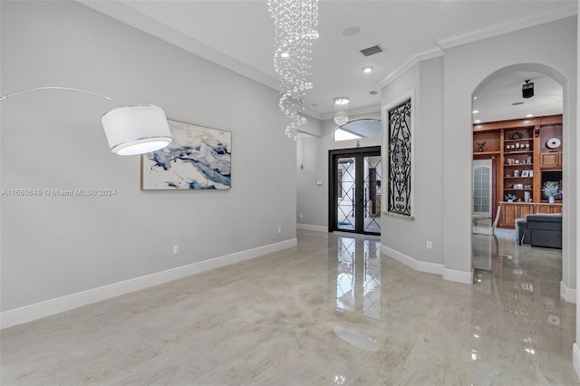 foyer entrance featuring french doors, a notable chandelier, and ornamental molding