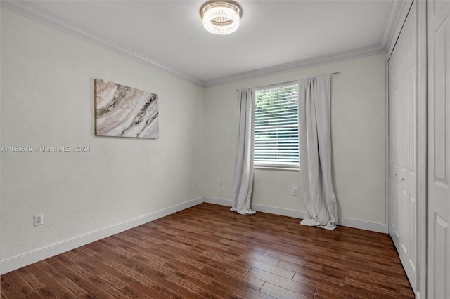 unfurnished bedroom with ornamental molding, dark wood-type flooring, and a closet