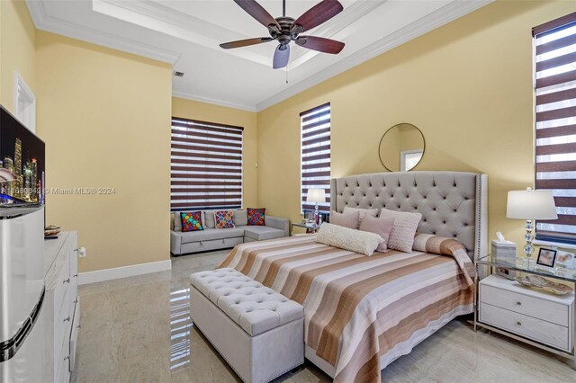 bedroom featuring ceiling fan, ornamental molding, and a tray ceiling