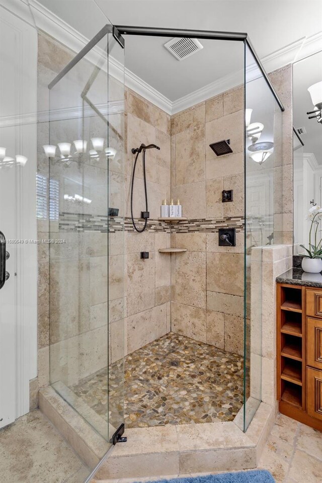 bathroom with vanity, a shower with shower door, and crown molding