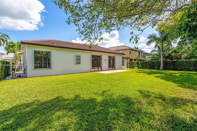 back of property with a yard and a patio area