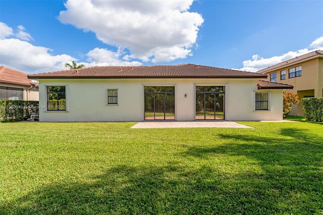 2294 SW 195th Ave, Miramar, FL 33029 - rear view of house with a patio area, a lawn, a tiled roof, and stucco siding