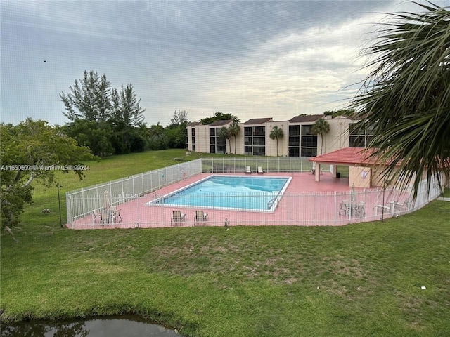 view of pool featuring a lawn