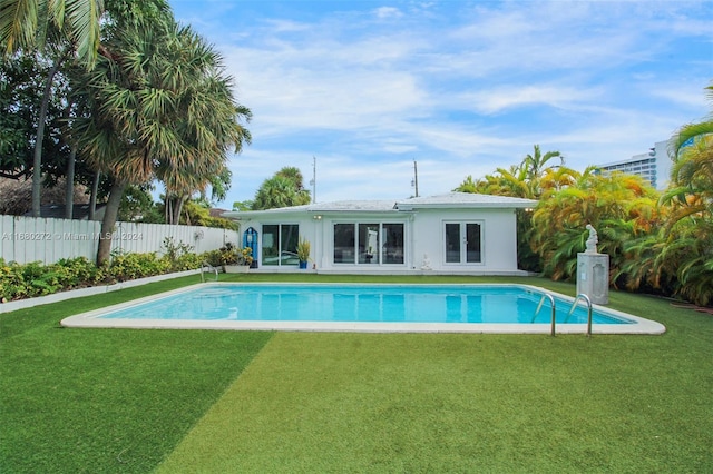 view of pool featuring a lawn