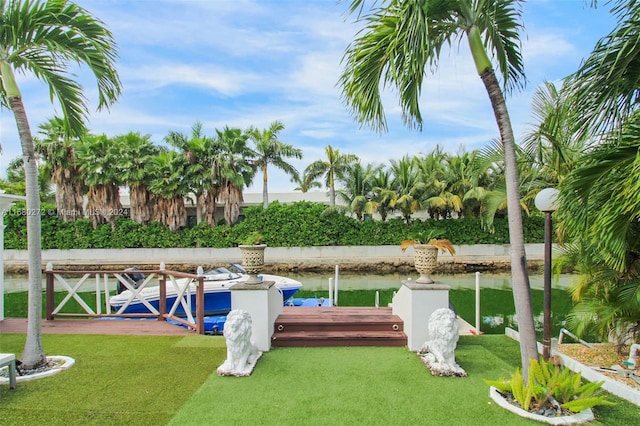 view of dock featuring a lawn and a water view