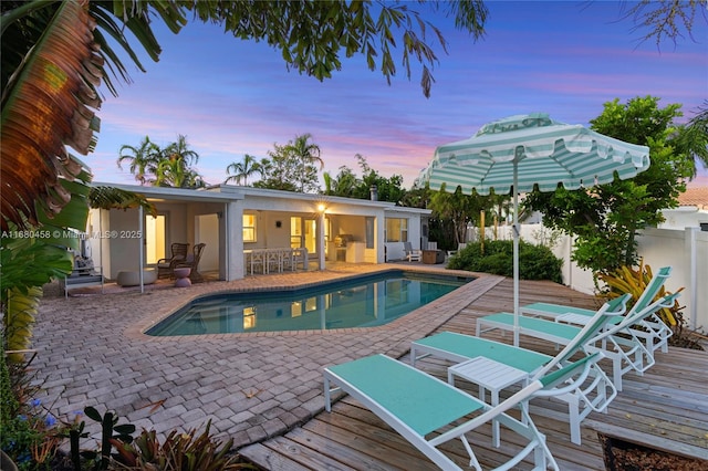 pool at dusk with a deck