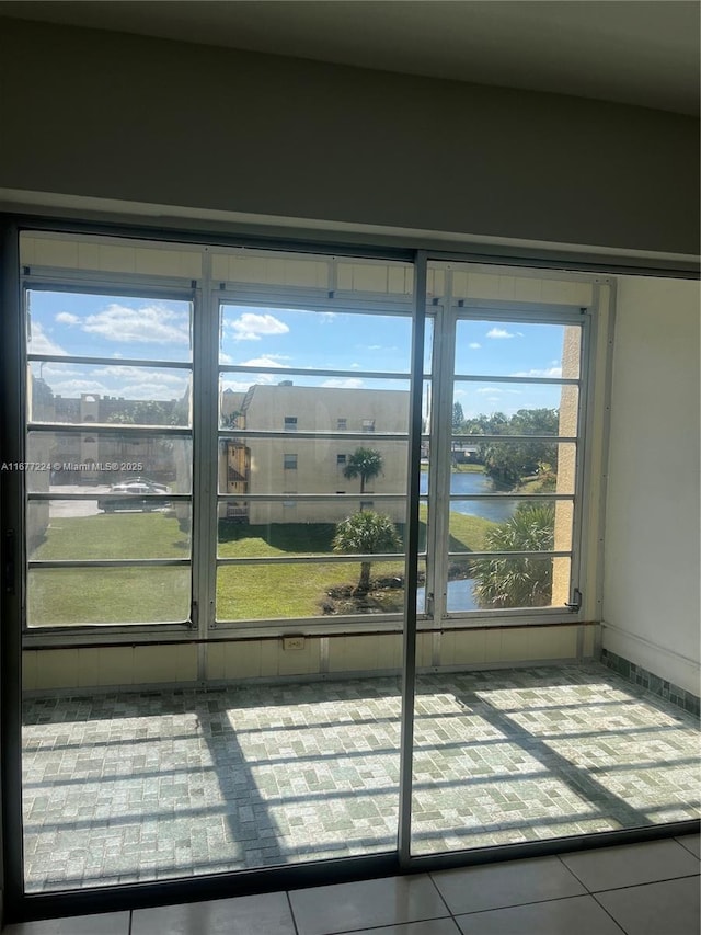 doorway featuring tile patterned flooring and a water view