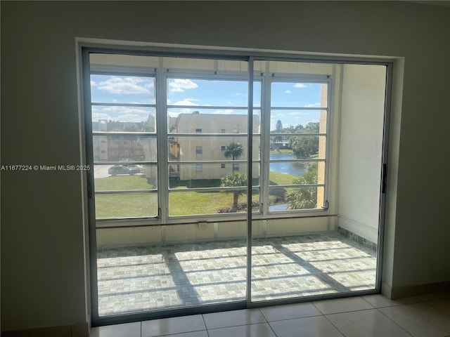 interior space featuring light tile patterned flooring and a water view