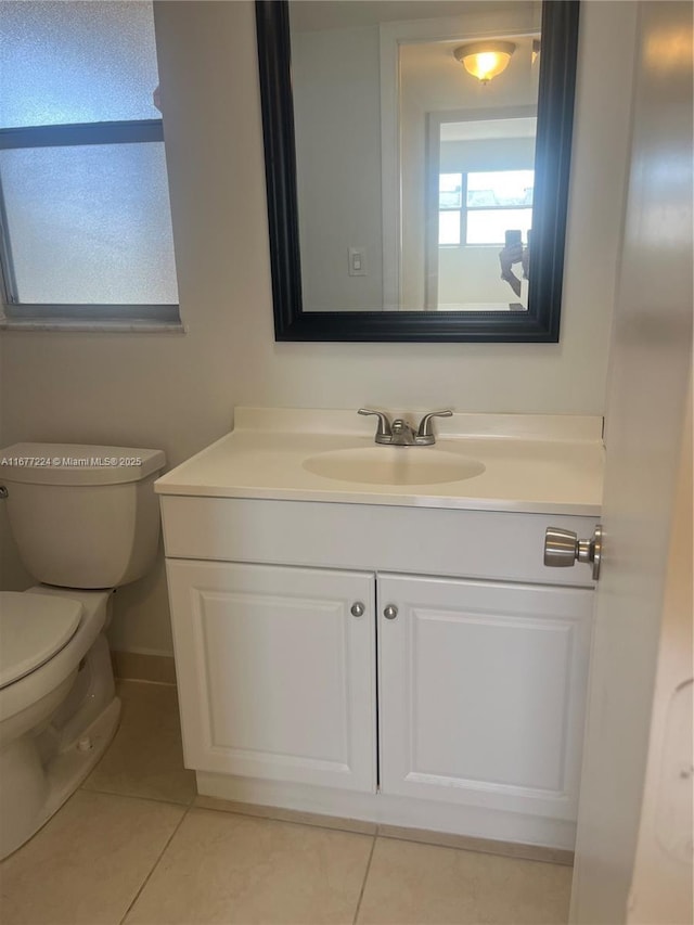 bathroom with tile patterned flooring, vanity, and toilet