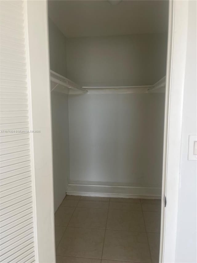 walk in closet with tile patterned floors