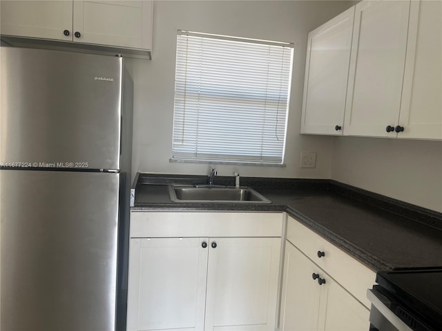 8285 Sunrise Lakes Blvd Unit 308, Sunrise, FL 33322 - kitchen featuring freestanding refrigerator, a sink, dark countertops, and white cabinetry