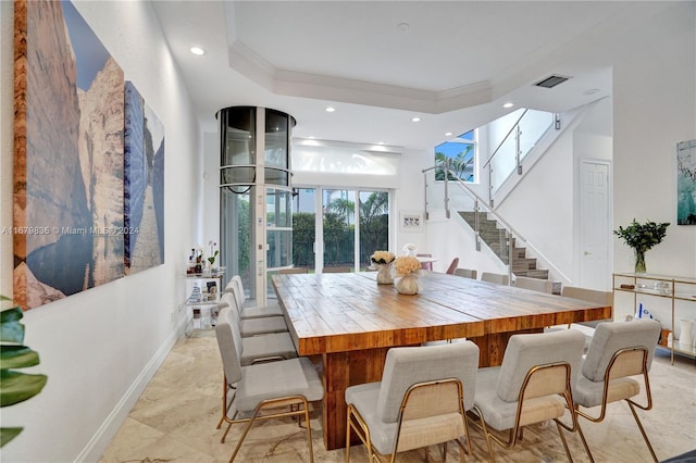 dining space with a tray ceiling and crown molding