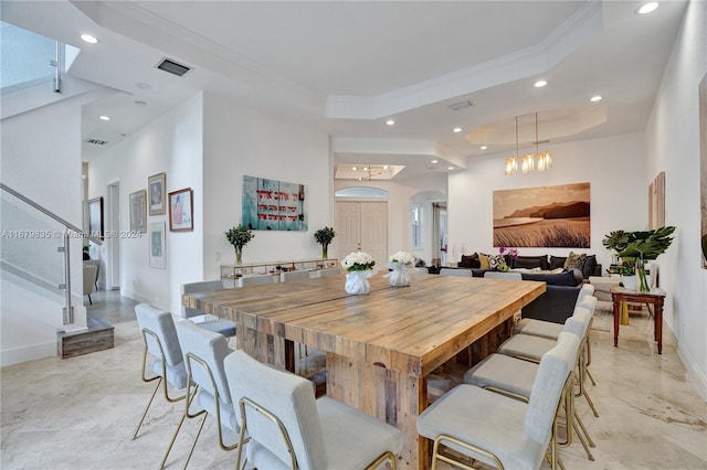 dining area featuring a chandelier, a tray ceiling, and ornamental molding