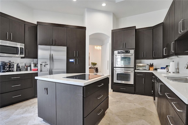 kitchen with sink, dark brown cabinets, a center island, and appliances with stainless steel finishes