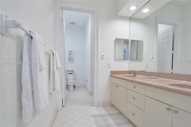 bathroom with tile patterned flooring, vanity, and toilet