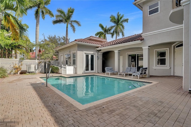 view of pool with central air condition unit and french doors