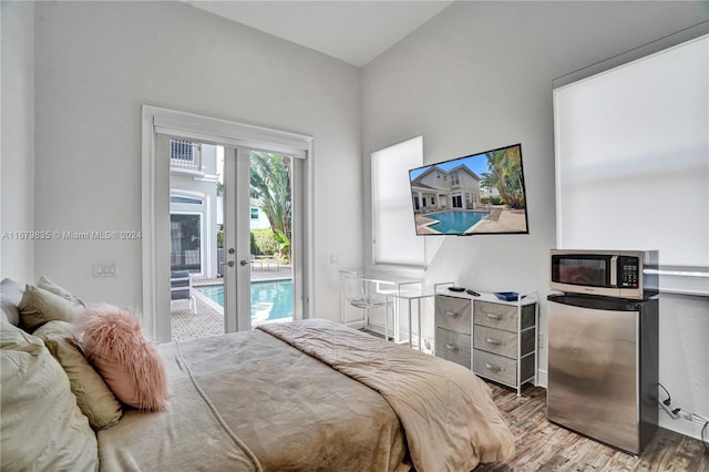 bedroom with wood-type flooring, refrigerator, access to outside, and french doors