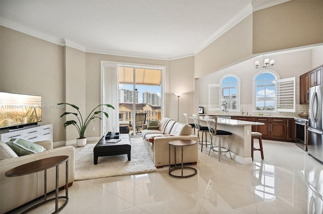 living area with a view of city, light tile patterned floors, an inviting chandelier, ornamental molding, and baseboards