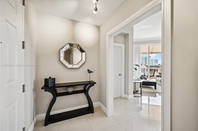 hallway featuring a textured ceiling and light tile patterned floors