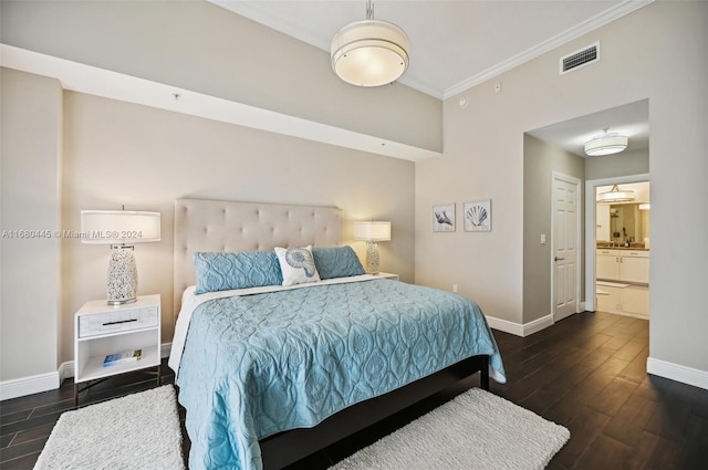 bedroom featuring crown molding, dark hardwood / wood-style floors, and connected bathroom