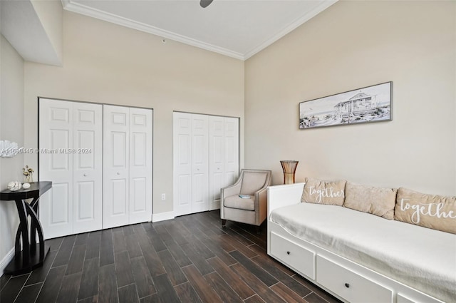 living area with ornamental molding, a high ceiling, and dark hardwood / wood-style flooring