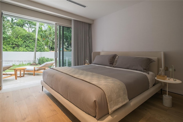 bedroom with access to outside and light wood-type flooring