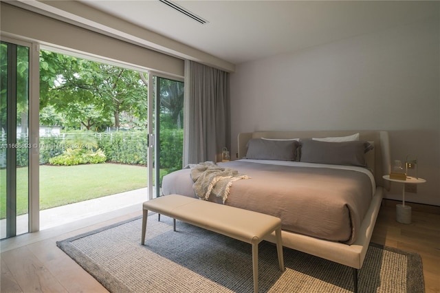 bedroom with light wood-type flooring and access to outside