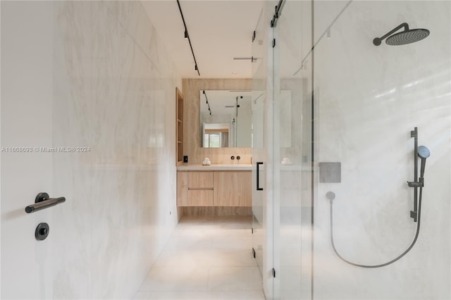 bathroom with vanity, an enclosed shower, tile patterned floors, and tile walls