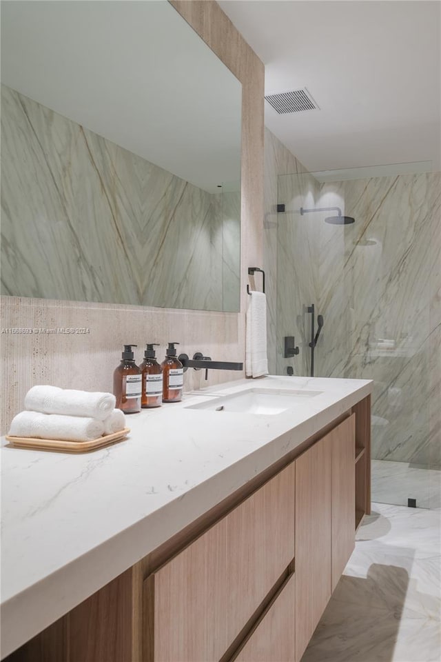 bathroom featuring vanity, tile walls, and tiled shower