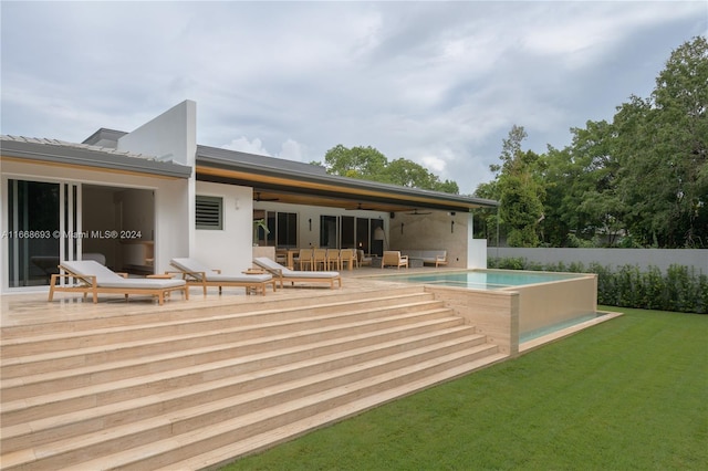 back of property with a yard, a patio area, a fenced in pool, and ceiling fan