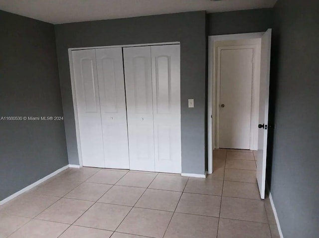 unfurnished bedroom with a closet and light tile patterned flooring